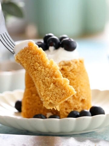 one yellow almond flour mug cake on a white plate.