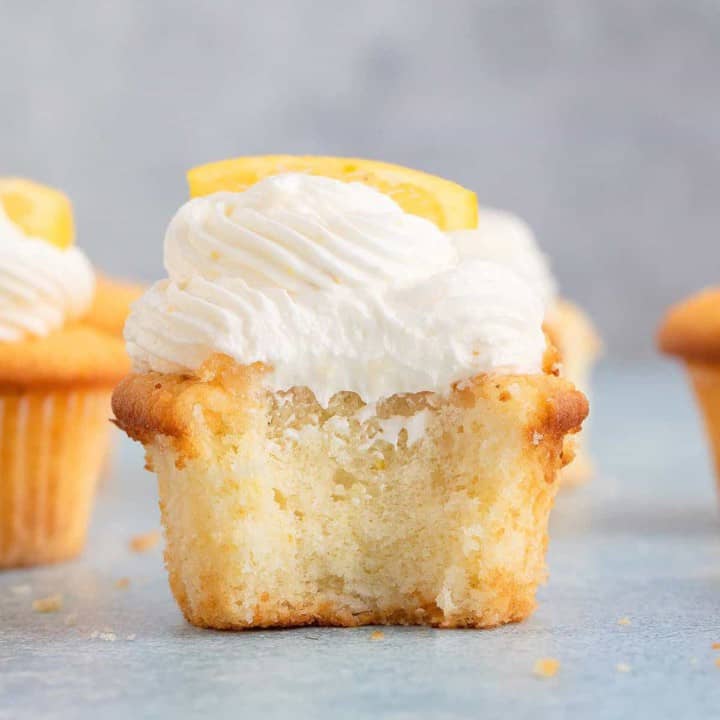half bitten soft lemon drizzle cupcake topped with lemon frosting.