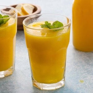 two glasses filled with yellow lemonade.
