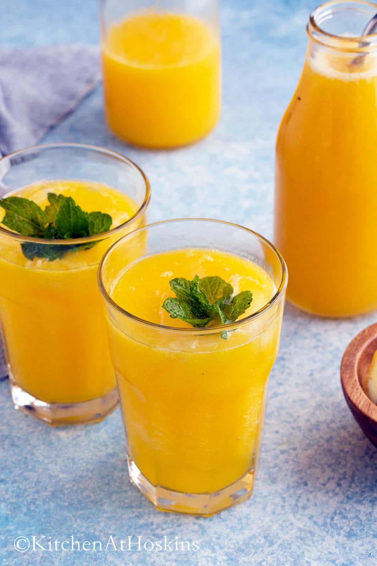 two drinking glass with mango lemonade.