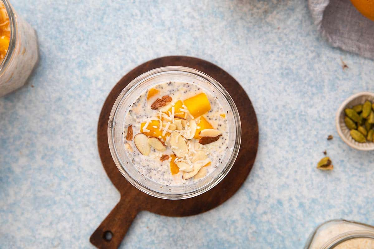 glass jar with oats, mixed with milk, yogurt and topped with fruits. 