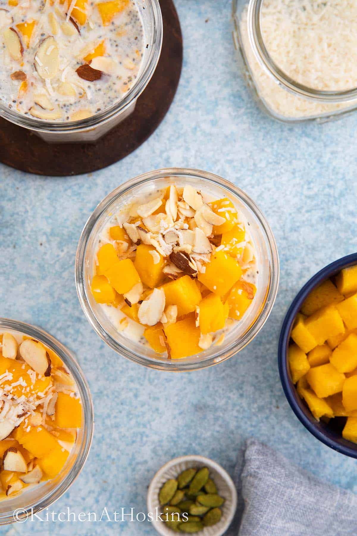 glass jars with overnight oats topped with mango.