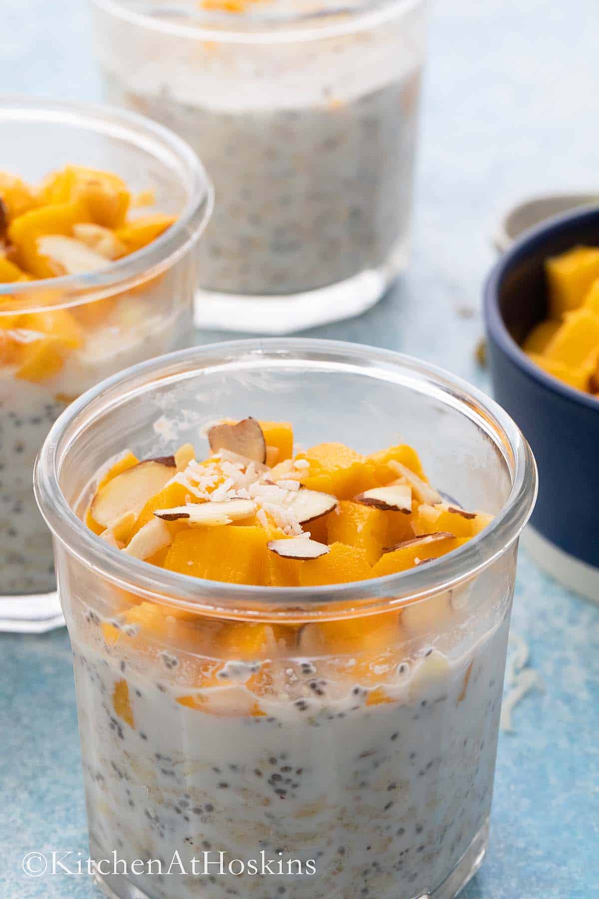mason jars with overnight oats topped with mango, coconut & almond.