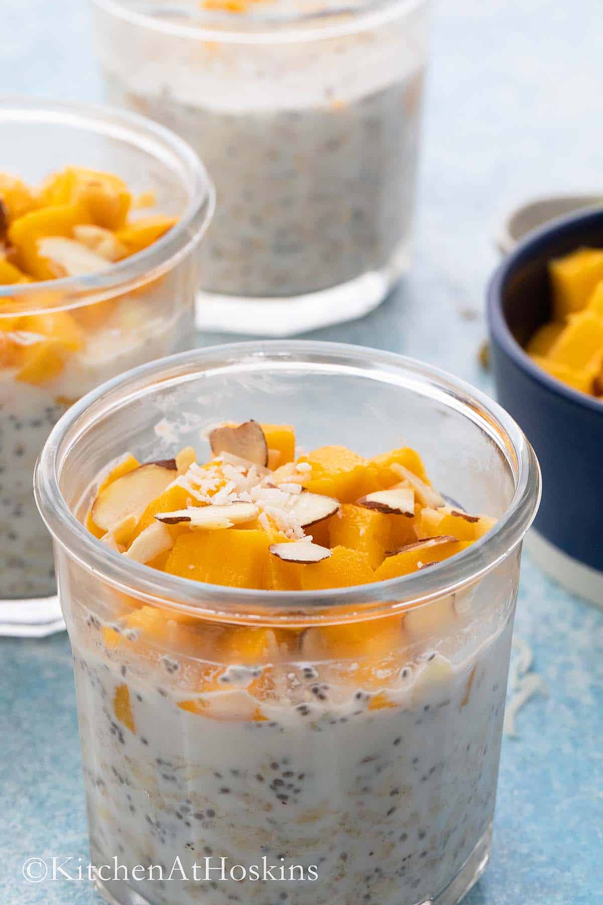 mango overnight oats in 3 glass jars.