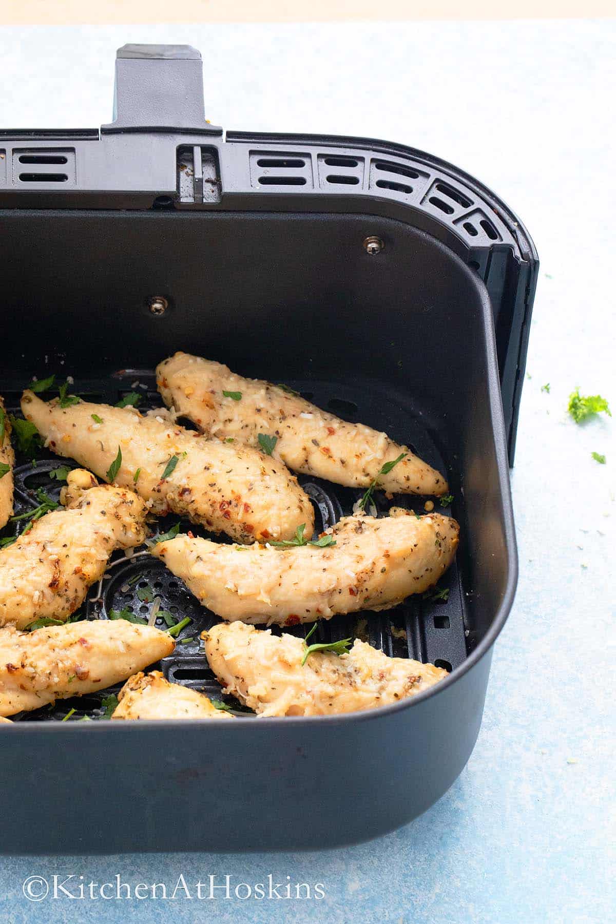 cooked no breading  chicken tenders in an air fryer basket.