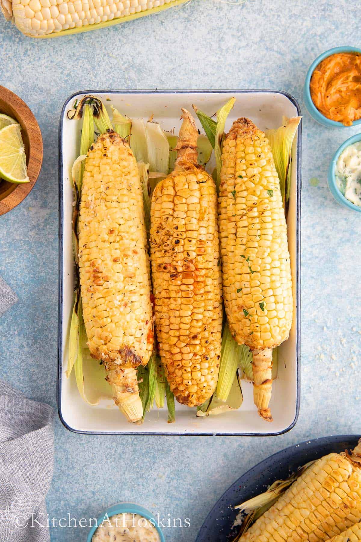 Air fry corn on the cob in husk 5 roasted corn on a white tray.