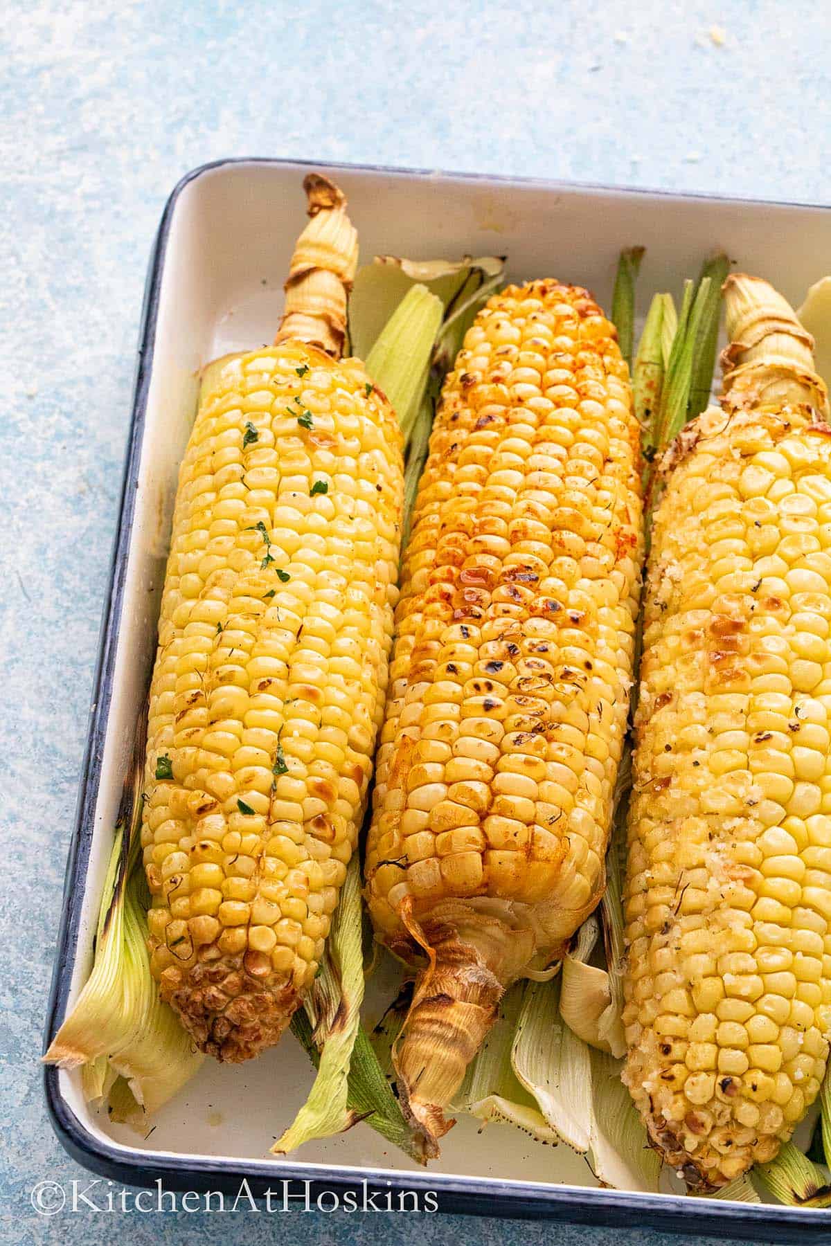 roasted corn on the cob on a tray. 
