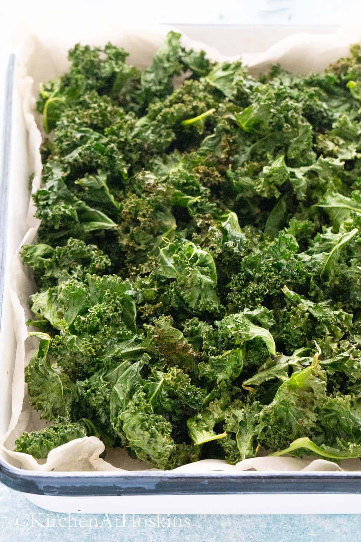 crispy air fryer kale chips in a white tray.