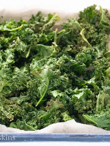 crispy kale chips in a white tray.