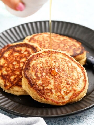 3 cooked pancakes placed on a round black plate.