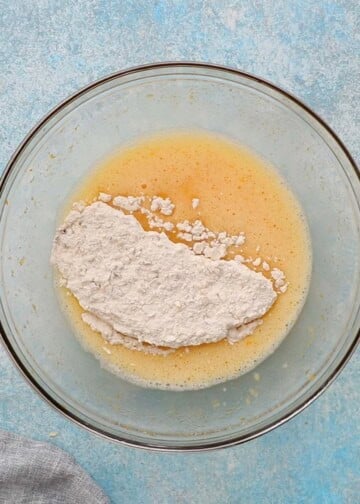 white flour and yellow liquid in a glass bowl.