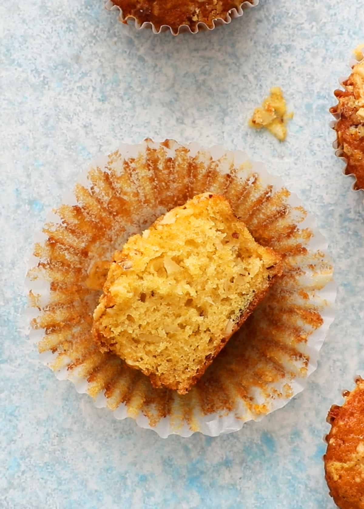 one cut orange muffin placed on a paper muffin liner.