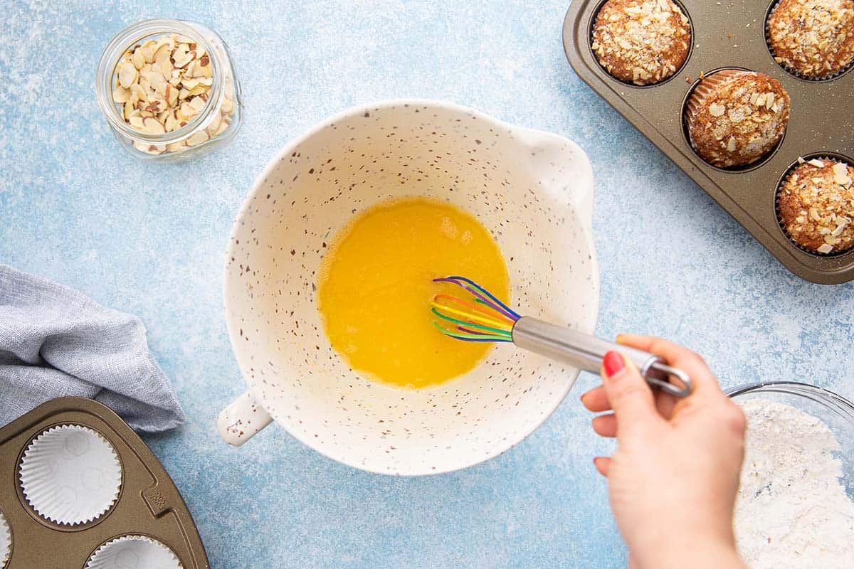 whisking egg, orange juice, oil and sugar in a bowl. 