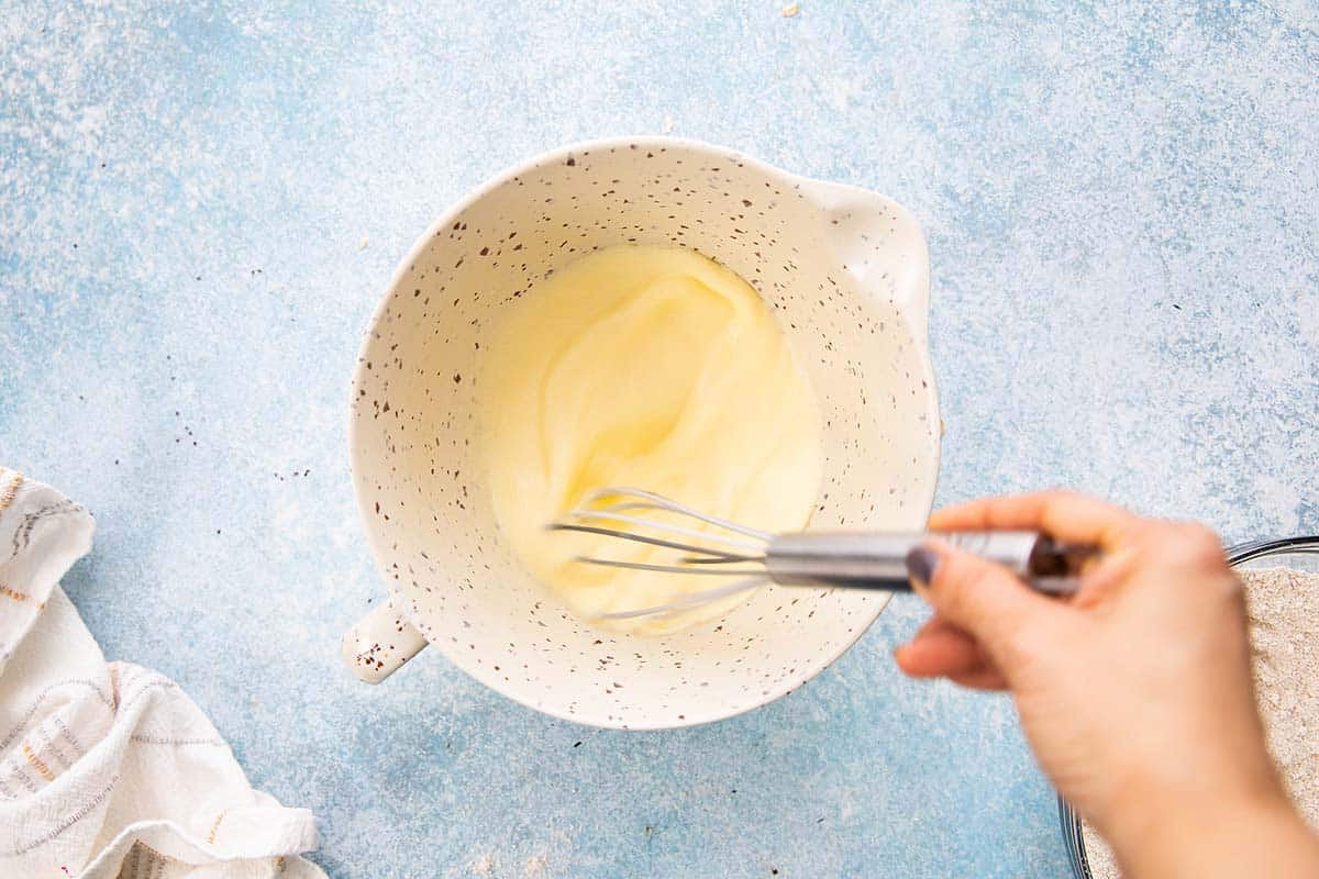 whisking wet ingredients in a glass bowl. 