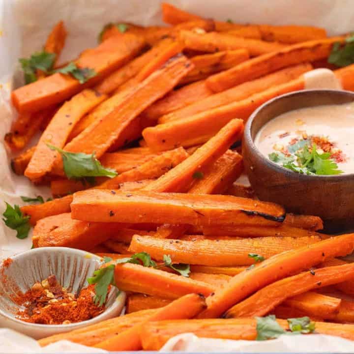 roasted carrot fries in a platter with dipping sauce.