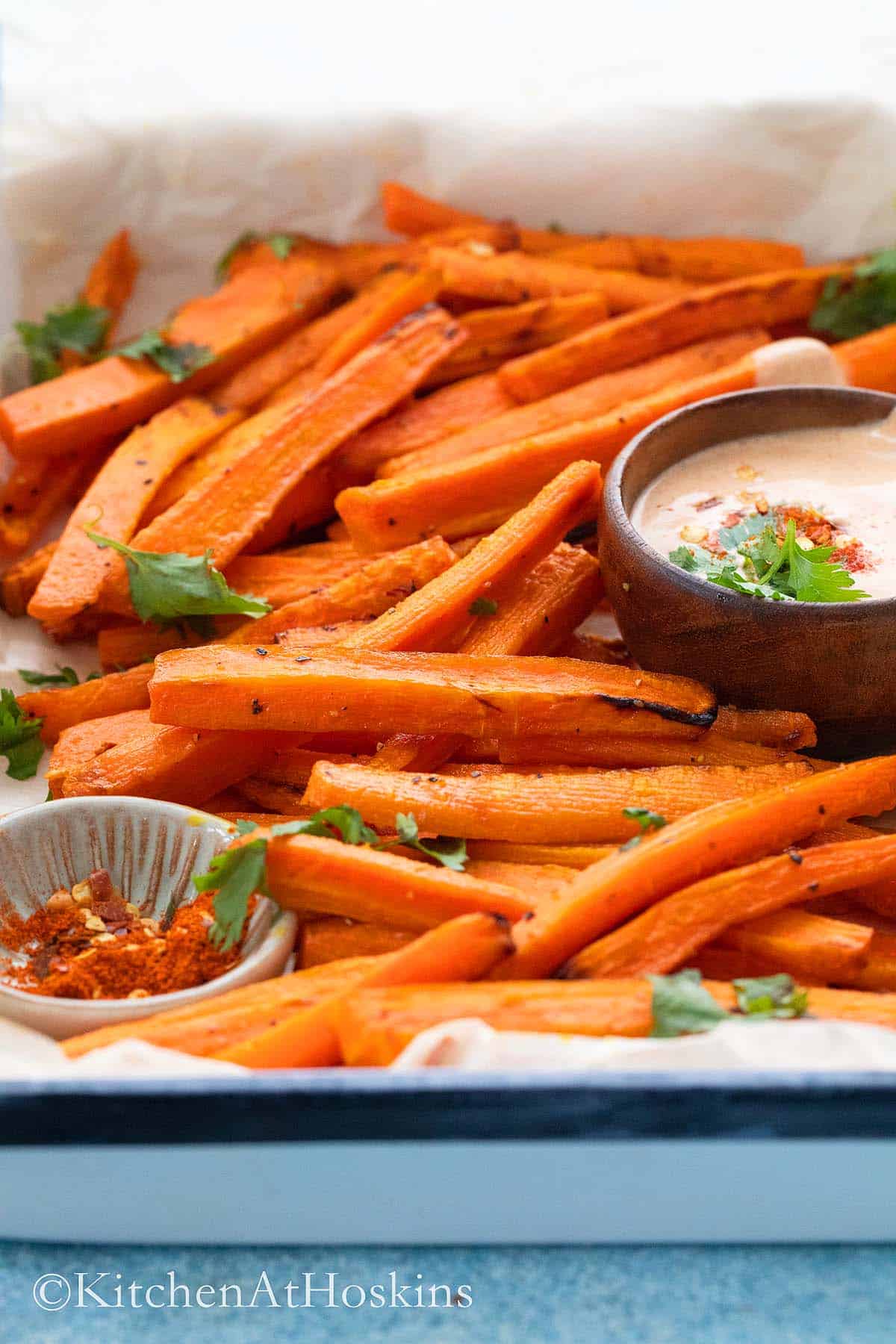 carrot fries roasted in air fryer and served in a white plate.