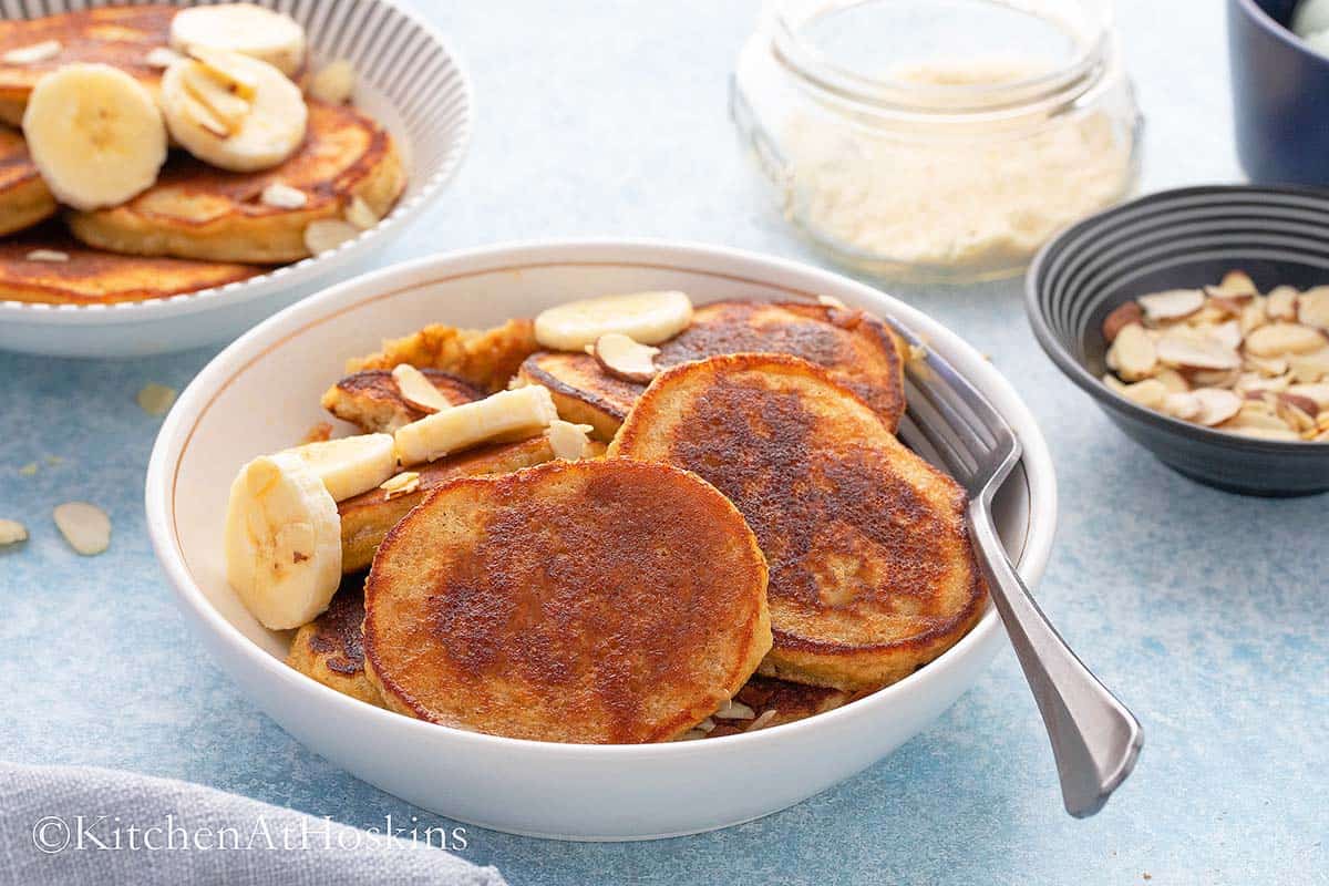 BANANA PANCAKES IN A WHITE BOWL WITH A FORK. 