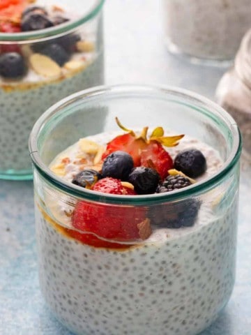 coconut chia pudding in glass jars with a spoon.