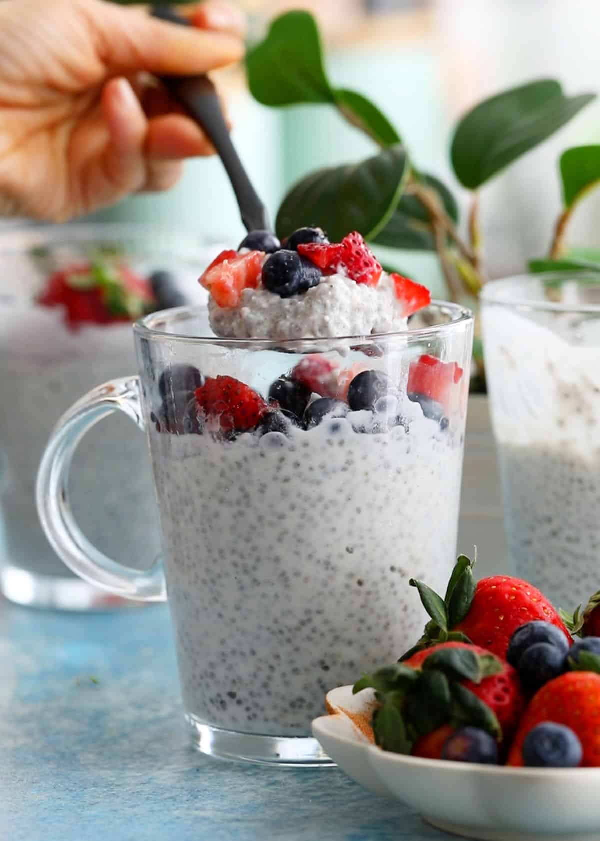 a spoonful of white coconut chia pudding above a glass jar.