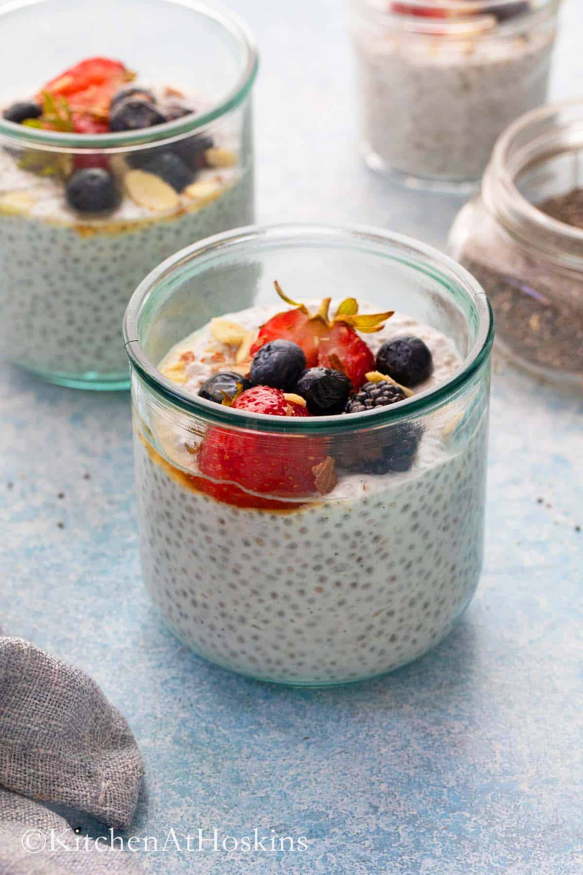 chai pudding made with coconut milk in jars topped with berries.