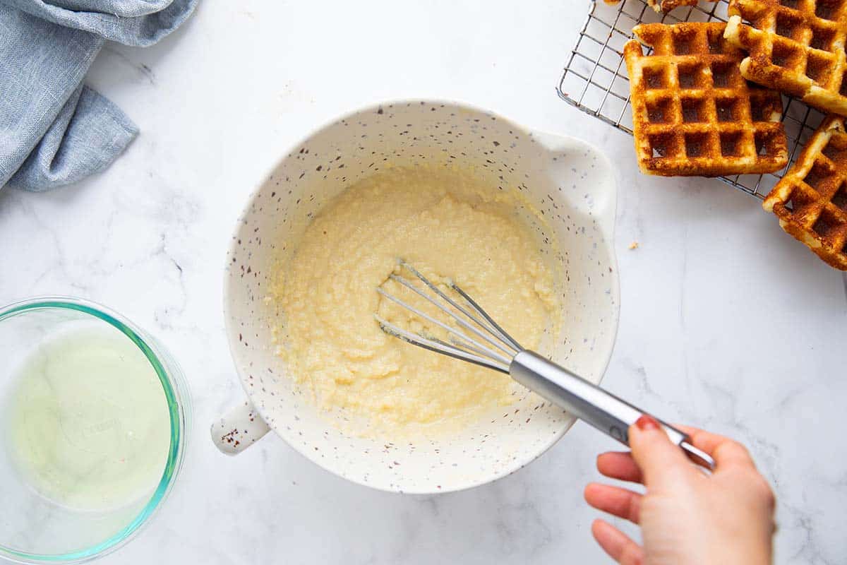 Whisking waffle batter in a bowl.