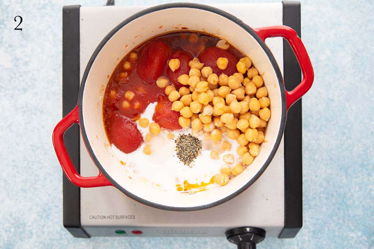 one red handled sauce pan with all chickpea soup ingredients.