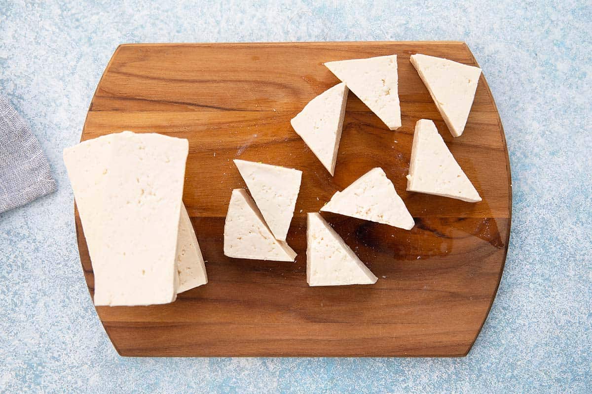 cut tofu triangles on a cutting board.