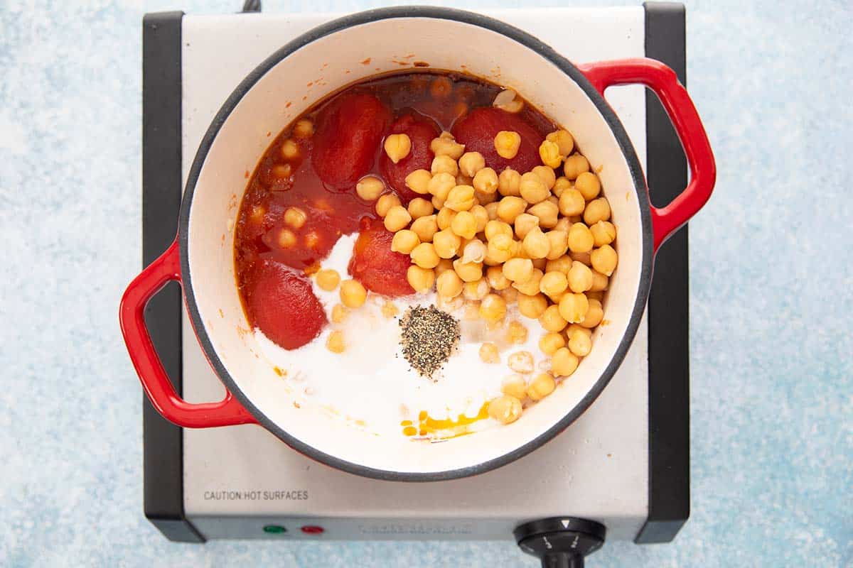 sauce pan with chickpeas, tomatoes and other ingredients.