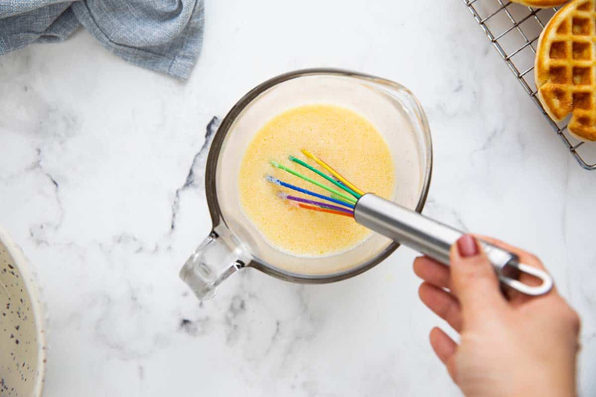 whisking wet ingredients in a measuring cup.