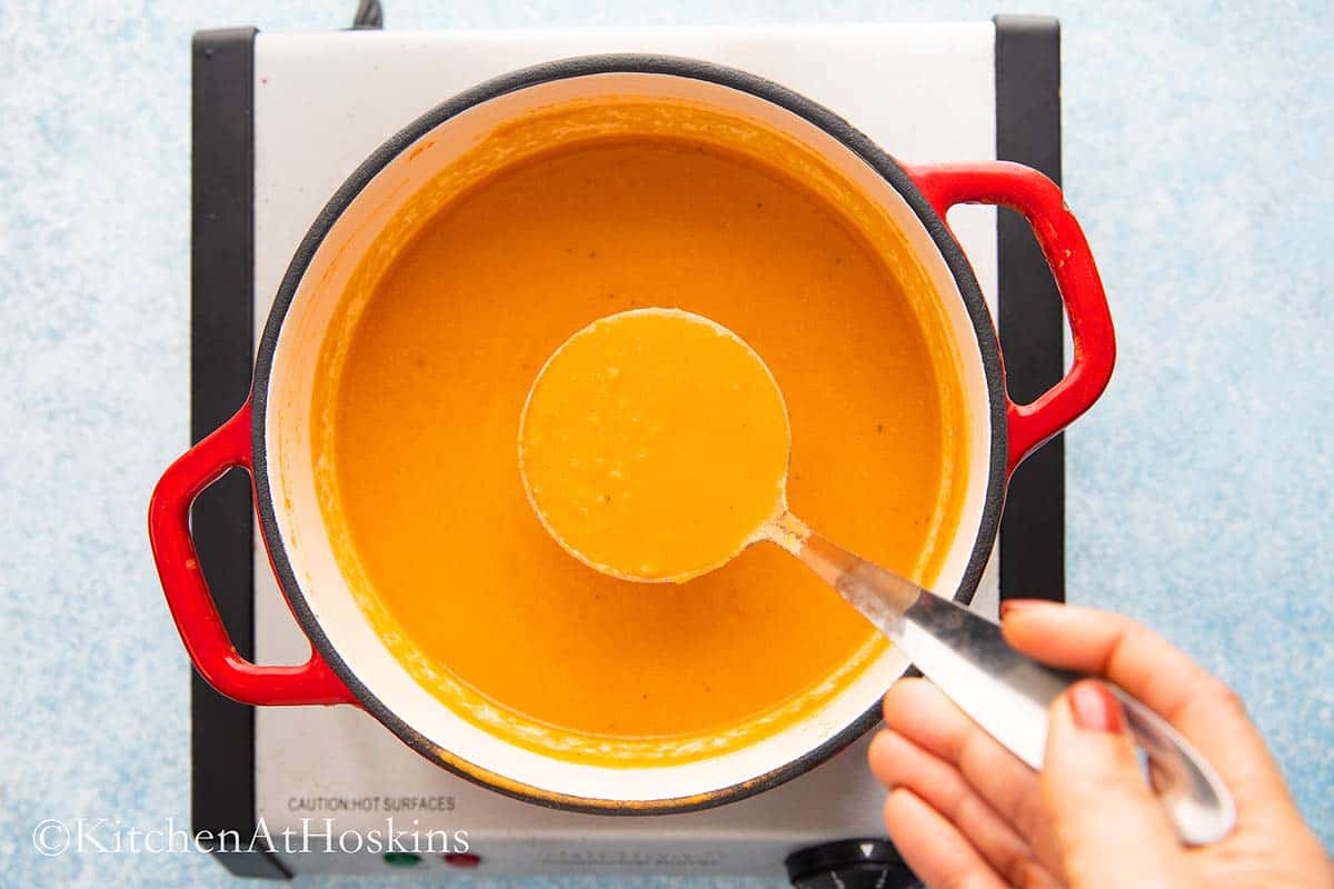 Removing a ladle of  creamy chickpea soup.