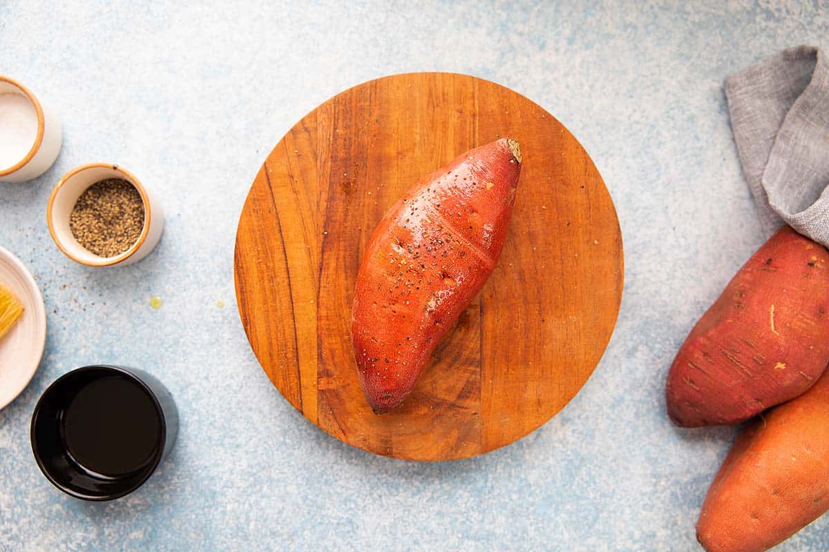 seasoned raw sweet potato on a wooden board.