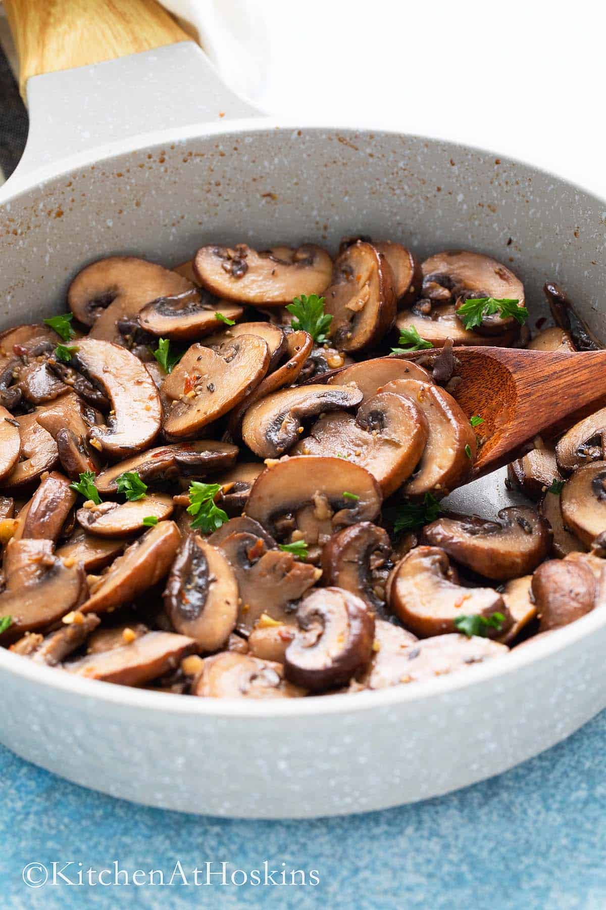 pan fried mushrooms in an skillet with spoon.