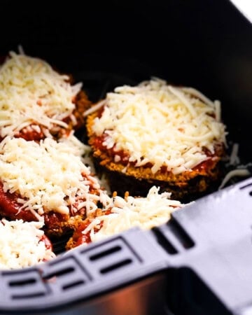 white shredded cheese topped on top of eggplant slices.