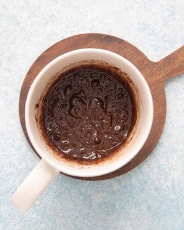 black Oreo cake batter in a white mug.