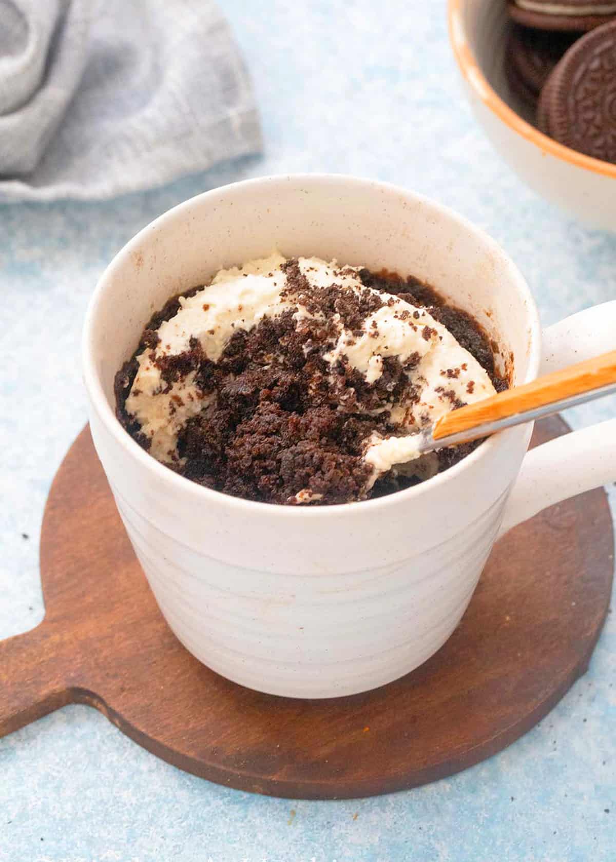 cooked oreo mug cake in a white mug.