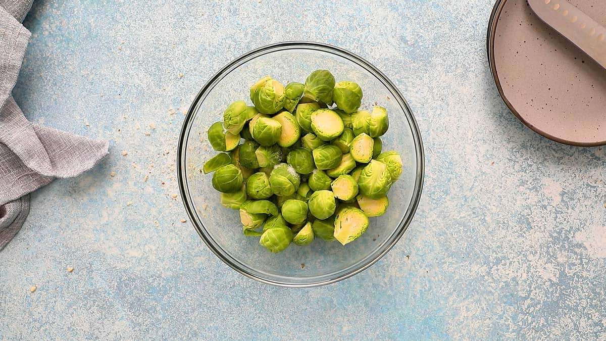 a glass bowl with cut brussels sprouts. 