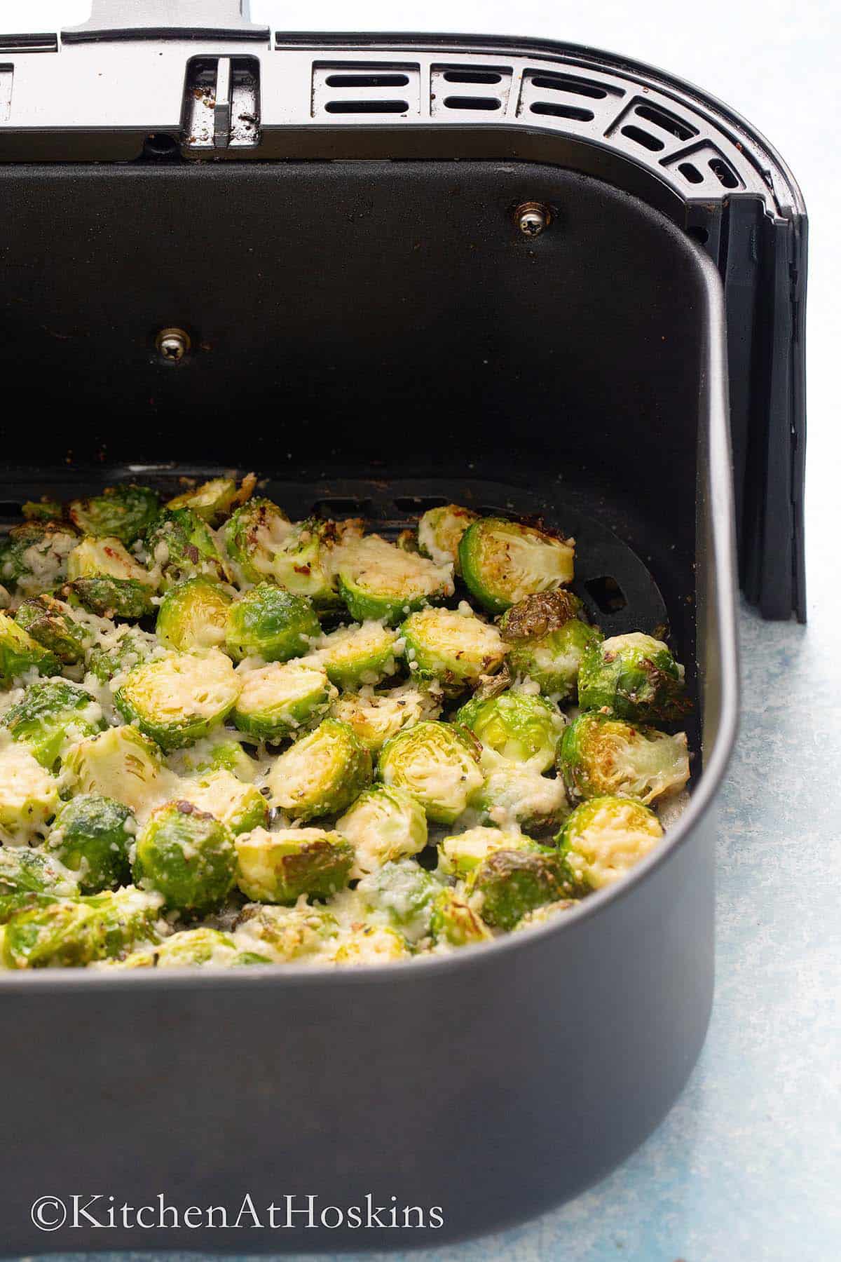 air fryer basket with roasted brussels sprouts.