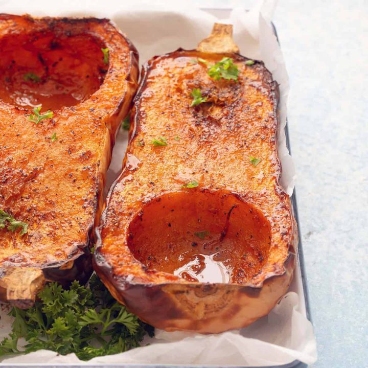 roasted butternut squash halves on a tray.