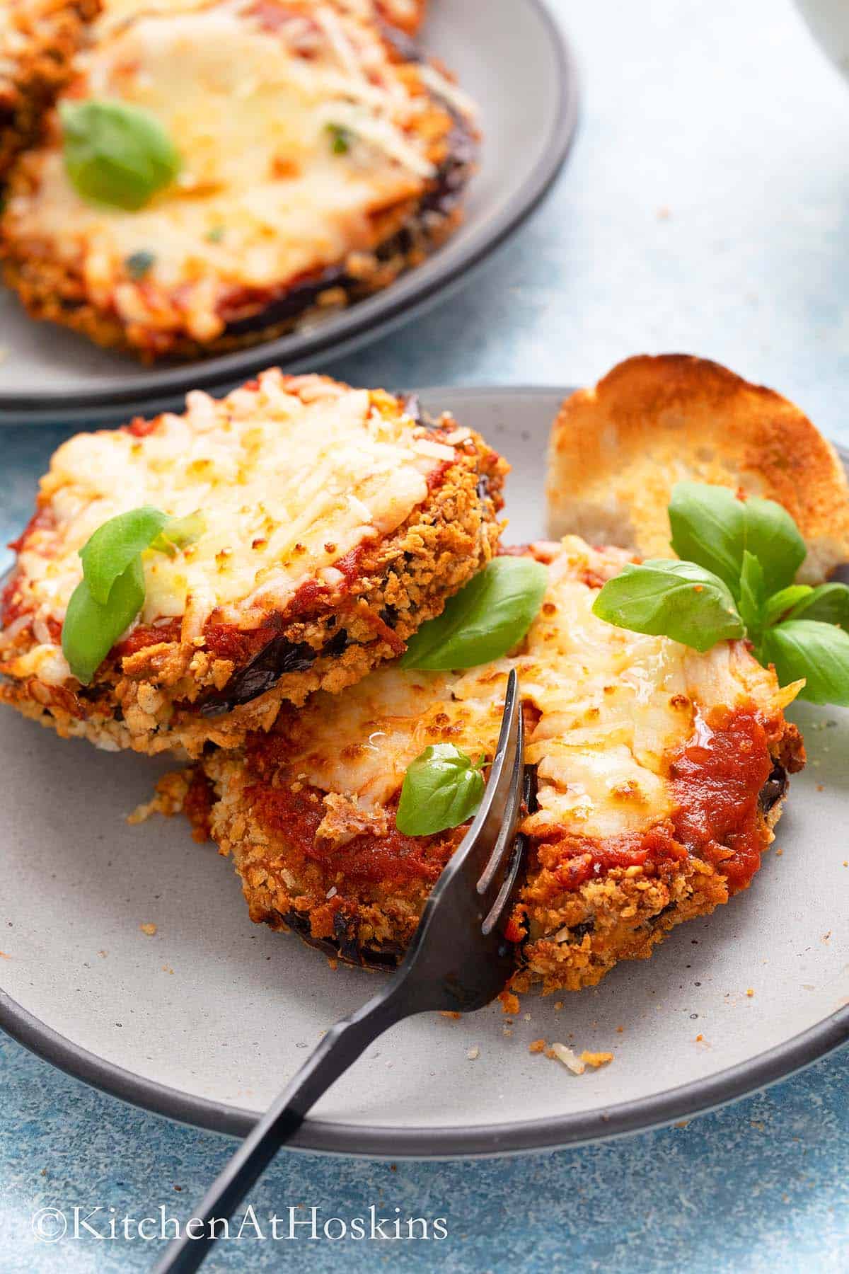 breaded eggplant parm in a plate with a fork.