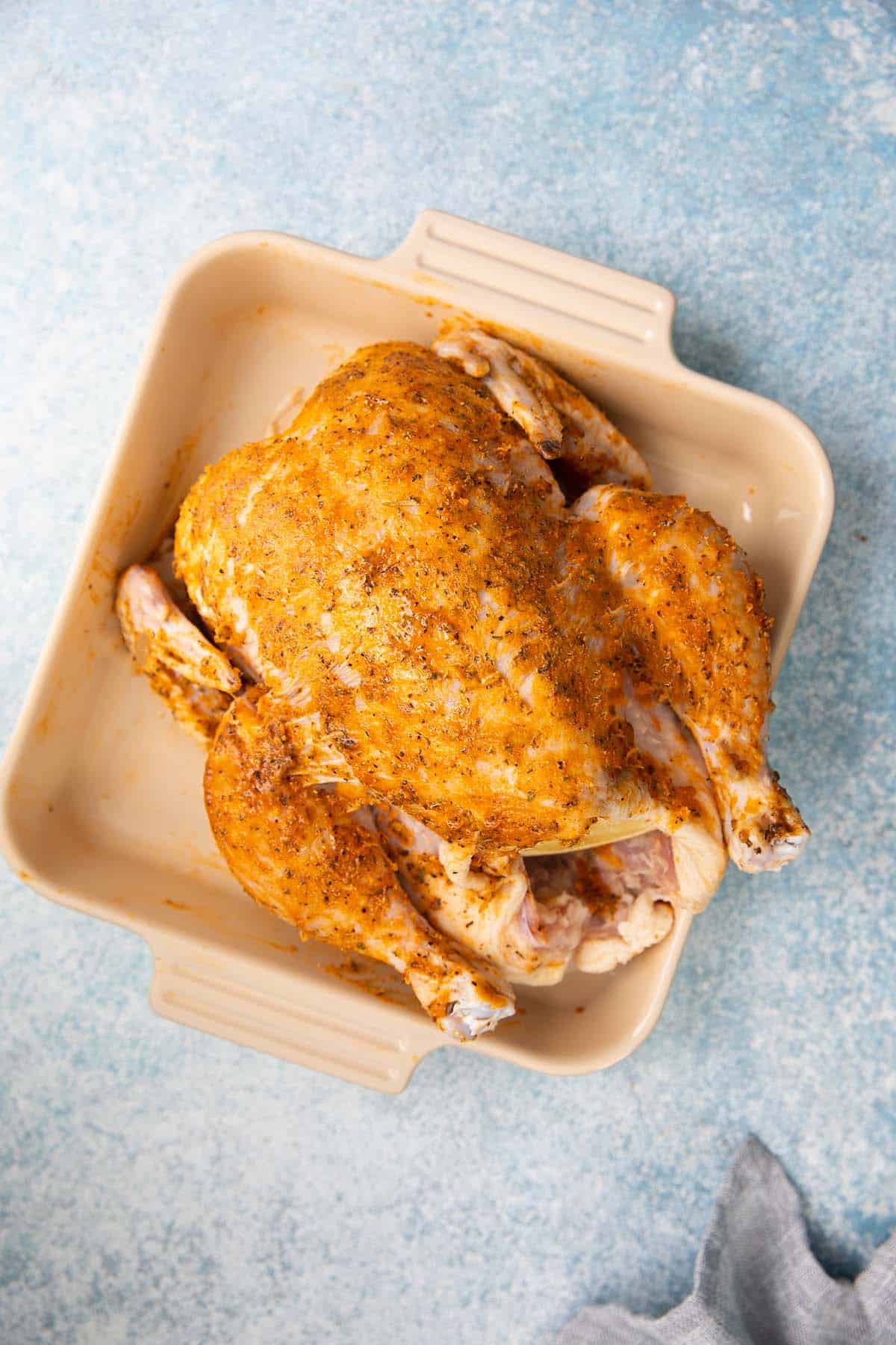 spice marinated full chicken in a tray ready to be air fried.