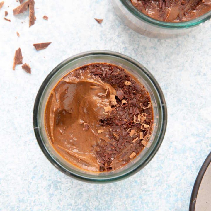 chocolate mousse in a glass cup garnished with chocolate curls.