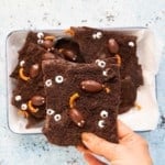 a hand holding a piece of hallowen chocolate bark.
