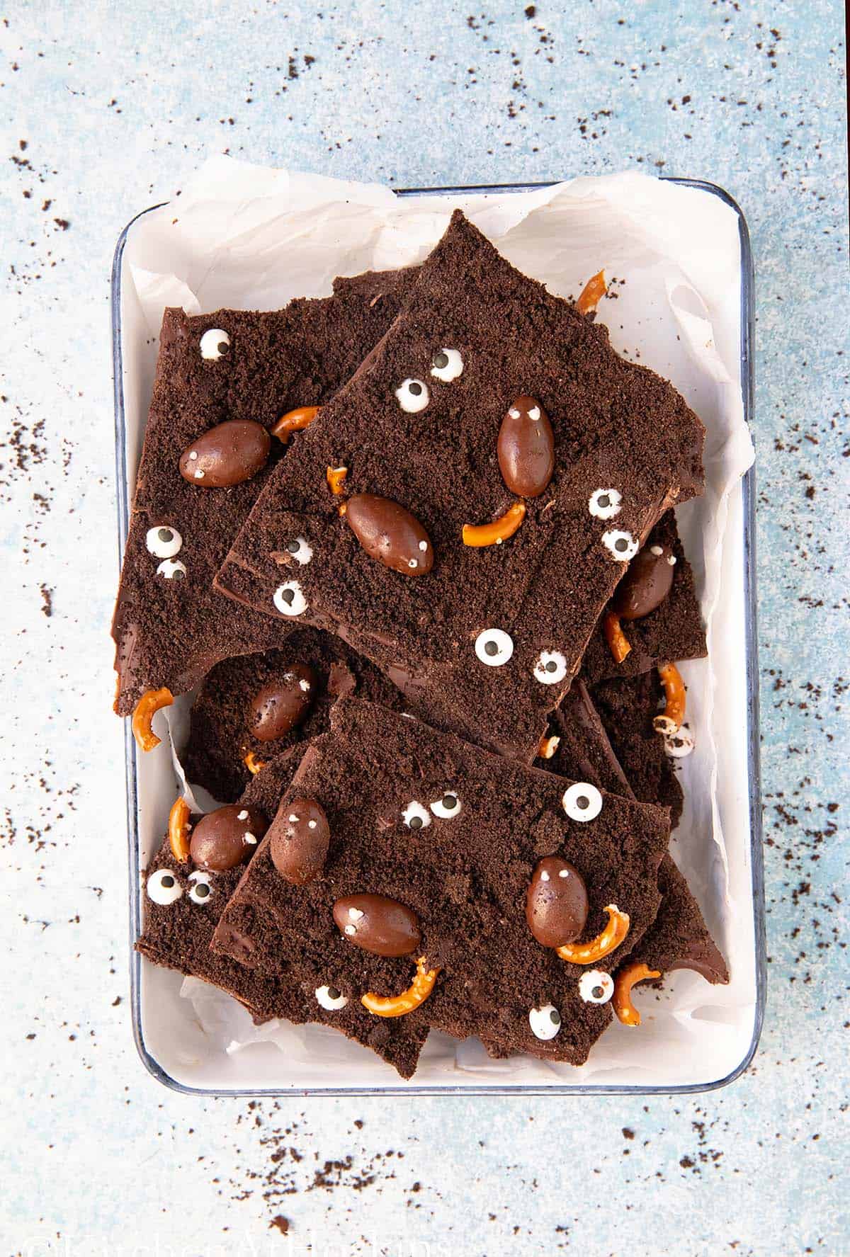 white tray with broken pieces of Halloween chocolate bark.