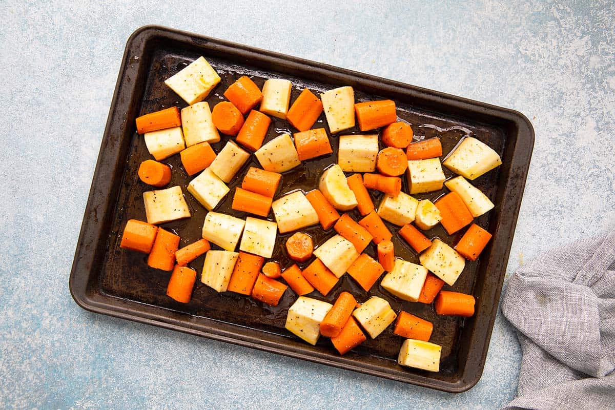 baking sheet with cut root vegetables with honey ready to be baked.