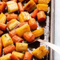 roasted carrots and parsnips in a baking sheet.