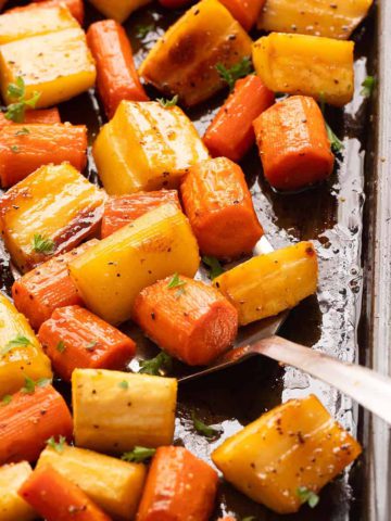 roasted carrots and parsnips in a baking sheet.