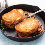 Cooked mushroom sandwiches on a cast iron skillet.