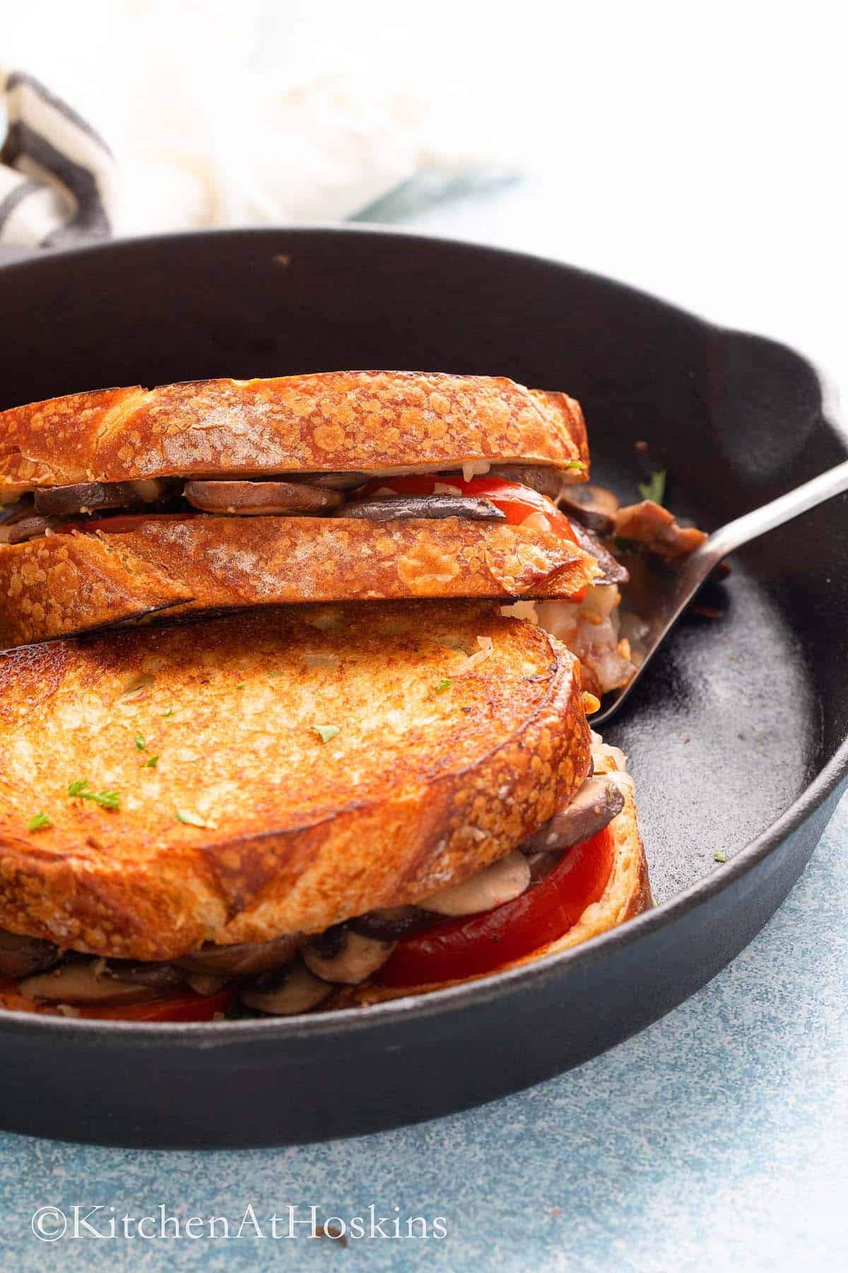 cooked sandwiches with tomato and cheese filling on a pan. 