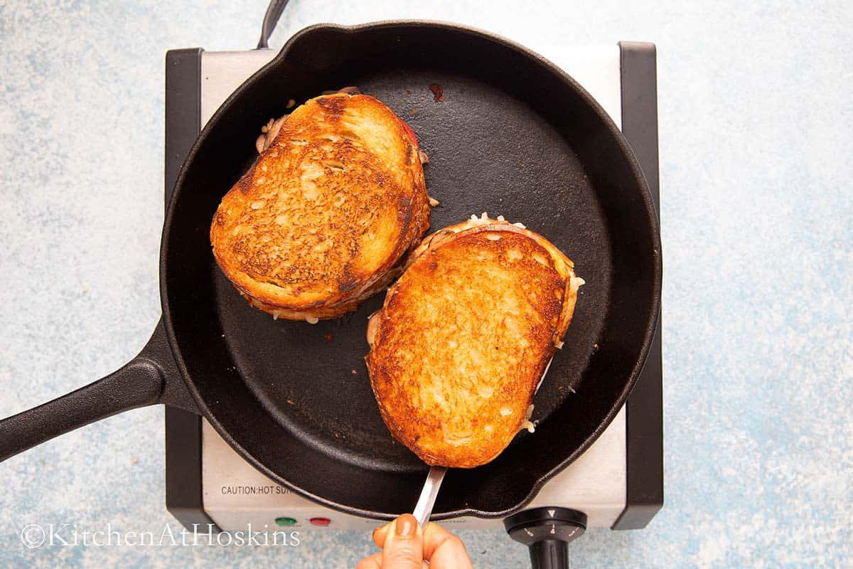 2 sandwiches cooked in a black skillet.