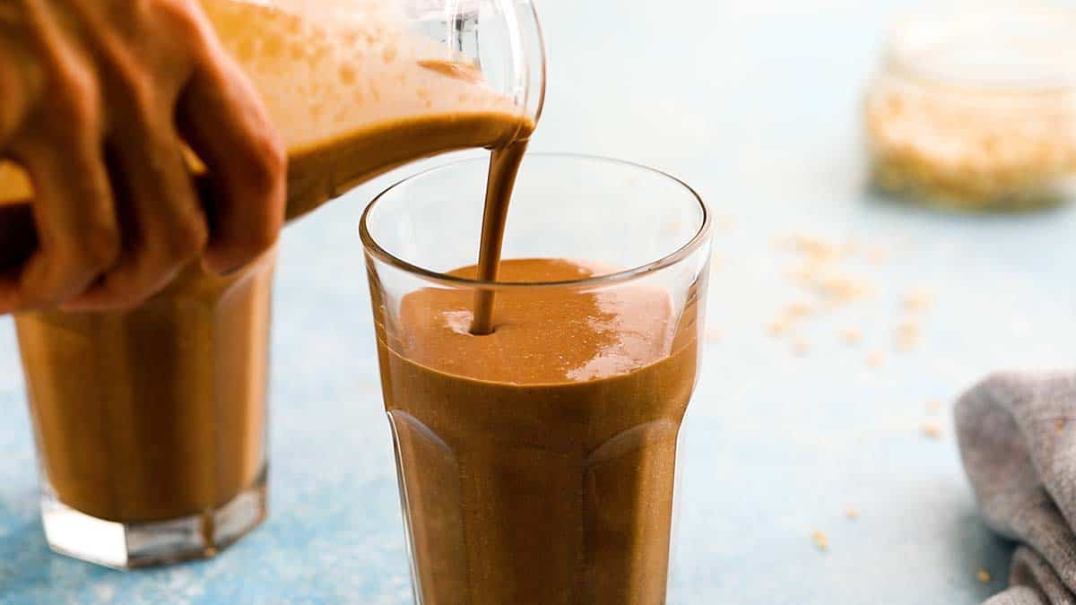 Pouring oats drink into a glass.